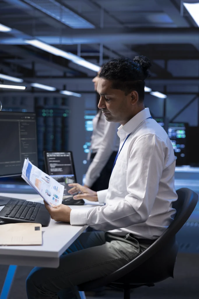 IT engineer reviewing system reports under an IT Annual Maintenance Contract in a server monitoring room